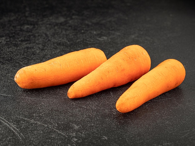 Three fresh carrots on grey