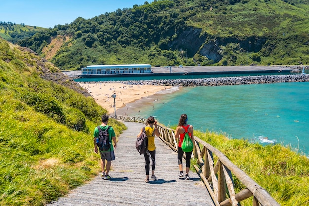 Three friends going down to Orio beach on a June summer afternoon