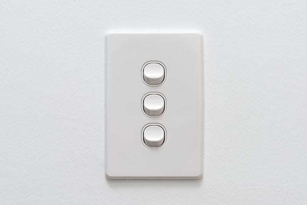 Three Gang white light switch on the wall