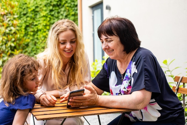 Three generations of women sitting at outdoor cafe terrace