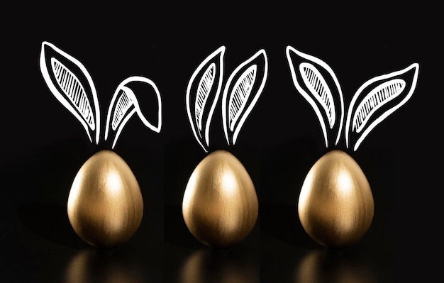 Three gold easter eggs with ears drawn on them, one of which has a rabbit on the top.