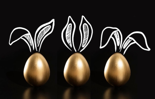 Three gold easter eggs with ears drawn on the top and the bottom left corner.