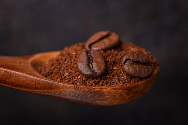 Three grains of coffee on a hammer in a wooden spoon