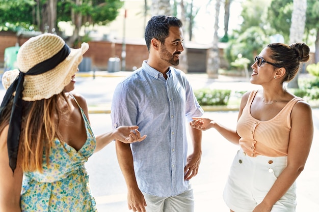 Three hispanic friends smiling happy standing at the city