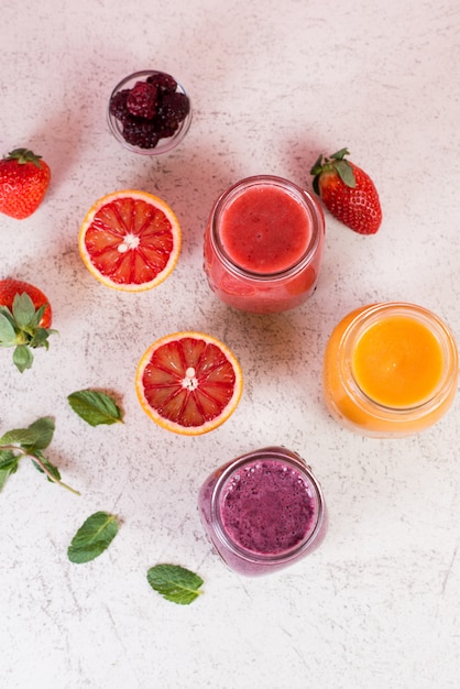 Three jars of tropical fruit smoothie on a white background. Flatley