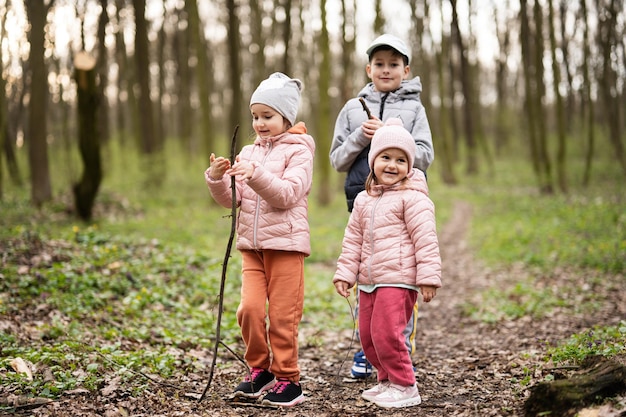 Three kids hiking and discovering spring forest Happy childhood