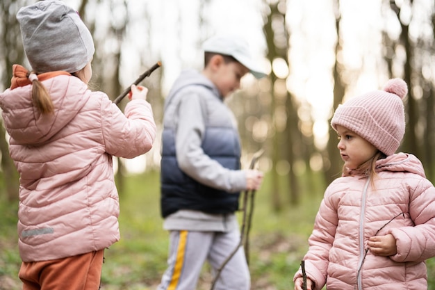 Three kids hiking and discovering spring forest Happy childhood