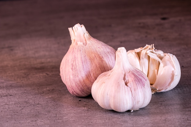 Three large heads of pink garlic on a kitchen worktop