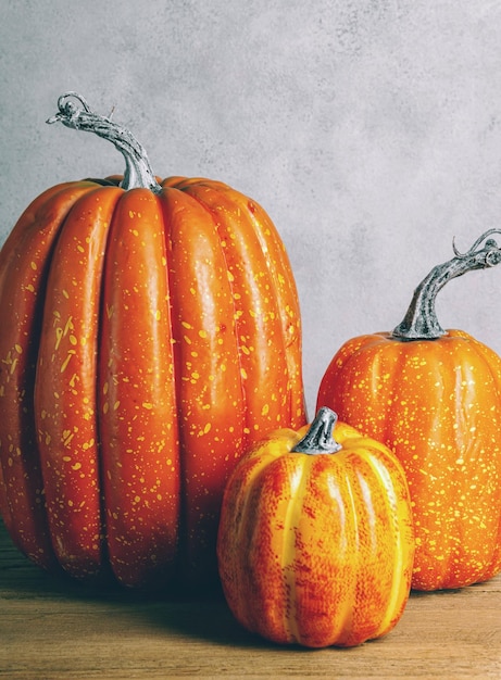 Three mockup pumpkins on wooden table Moody Style Halloween concept Autumn fall Copy space