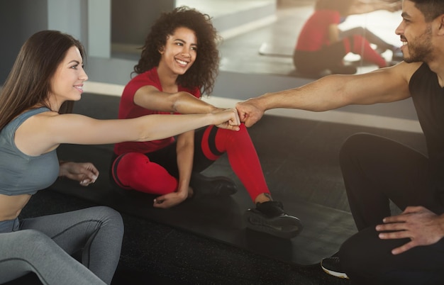 Three multiracial friends having sport greeting before workout at gym