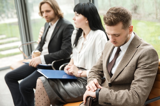 Three office workers are waitig for an appointment