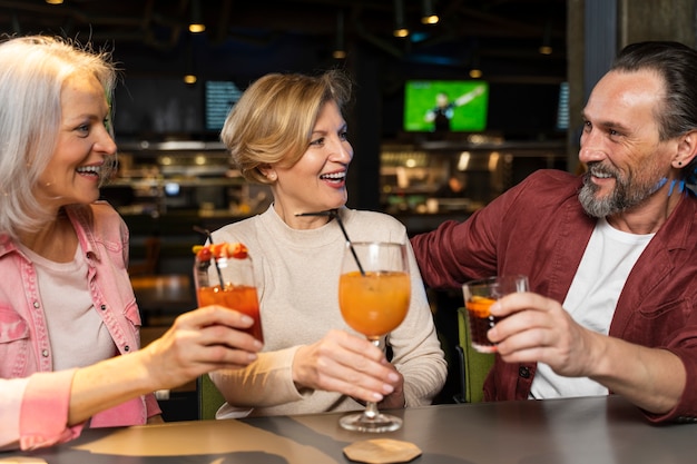 Three older friends drinking at a restaurant