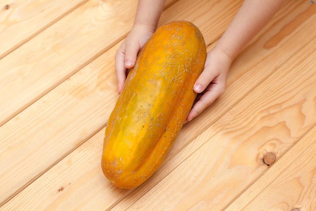 Three overripe yellow cucumbers on the background of old wooden boards Autumn harvest Vegetables and dry leaves stems selective focus High quality photo