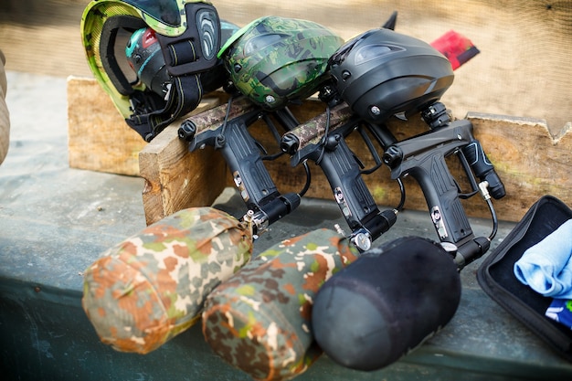 Three paintball markers with air balloons stand in row on board