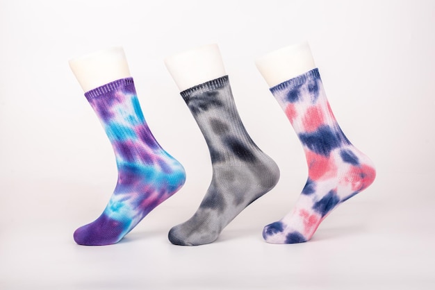 Three pairs of socks of different colors and styles are sleeved on the foot mold on a white background