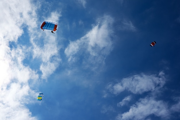 Three paraplanes in blue sky