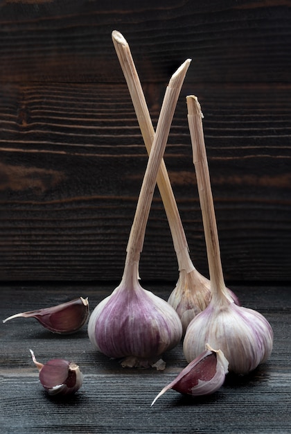 Three pieces of garlic on dark wooden desk surface