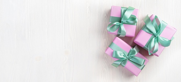 Three pink gift boxes on a light background The concept of holidays