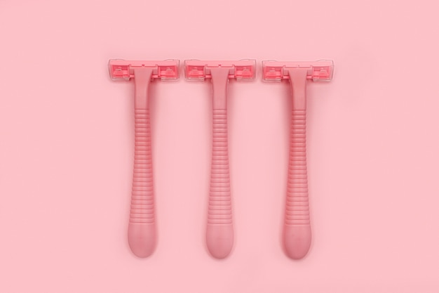 Three pink woman shaver isolated on pink paper  copyspace, . Flat lay. Shaving 