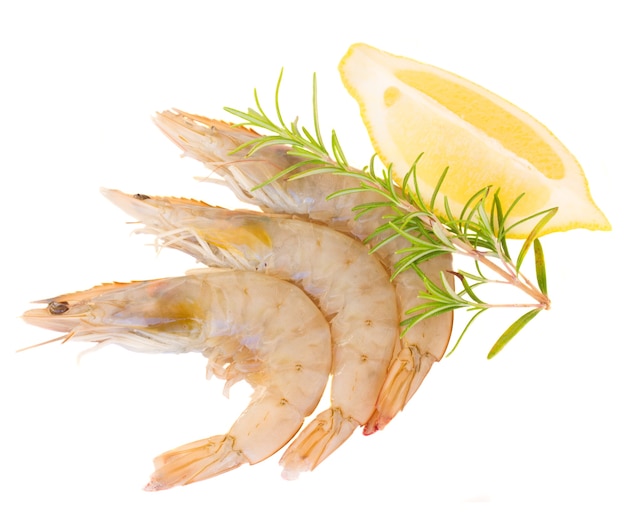 Three raw prawns with lemon and twig of rosemary isolated on white background