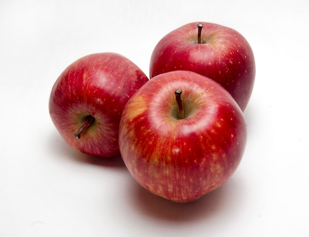 Three red apples on a white background