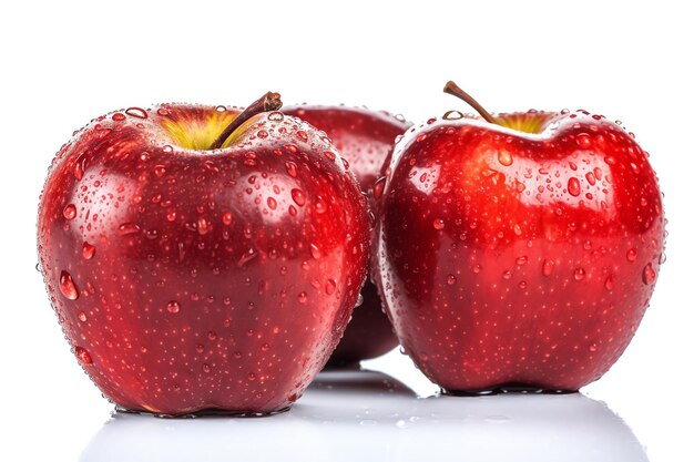 Three red apples with water droplets on them sit on a white surface