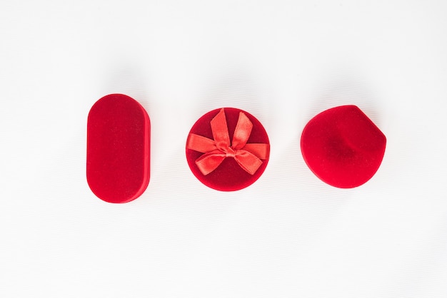 Three red closed jewelry boxes on a white