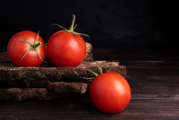 Three red fresh tomato on wooden table