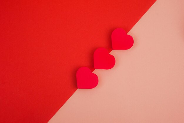 Photo three red hearts on a redpink background