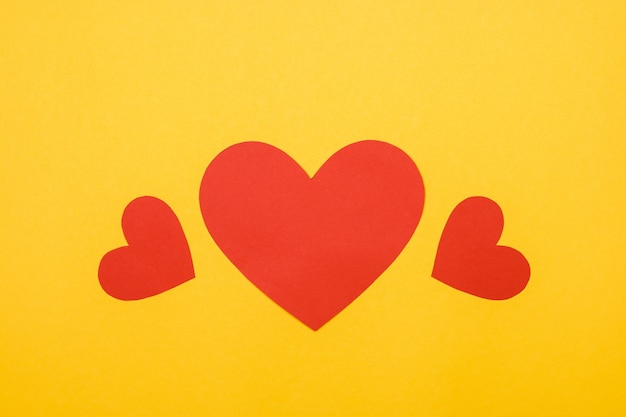 Three red hearts on yellow wall