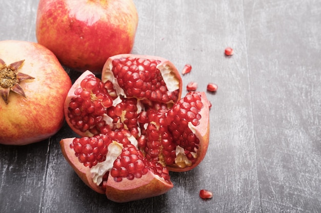 Three red juicy pomegranates on a wooden table