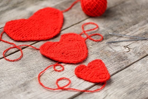 Three red knitted hearts, symbolizing love and family. Family relationship, bonds.