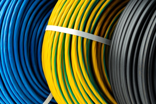 Three rolls of electrical wire in blue yellow and green and black colors