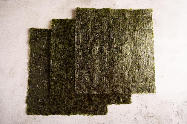 Three sheets of seaweed nori on a light background