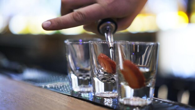 Photo three shot glasses on bar counter on background of bokeh lights