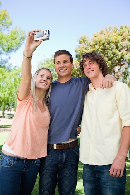 Three smiling friends taking a pictures of themselves