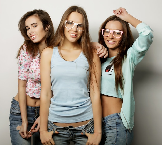 Three stylish sexy hipster girls best friends. Over white background.