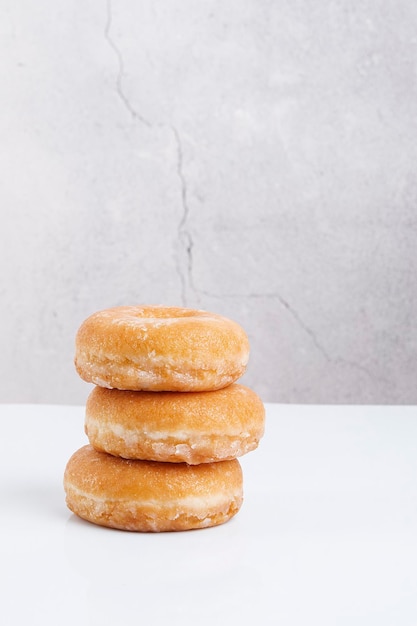 three sugar doughnuts stone color background