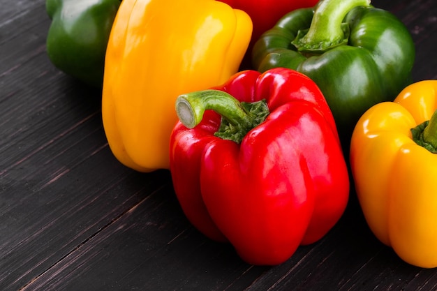 Three sweet peppers on a wooden background Cooking vegetable salad