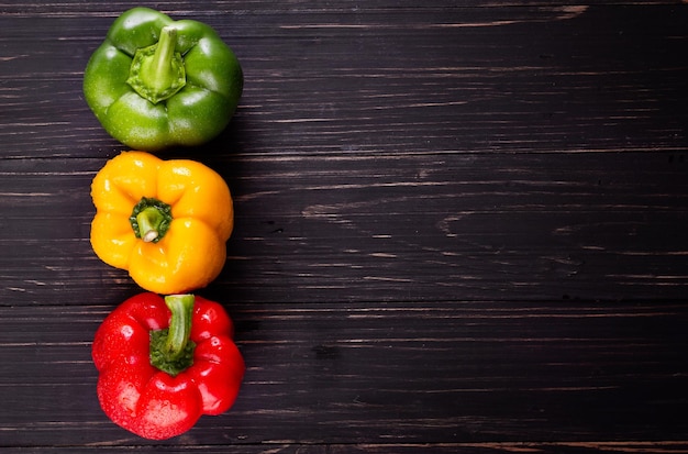 Three sweet peppers on a wooden background Cooking vegetable salad