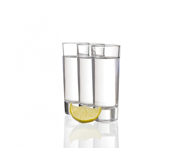 Three  tequila shots with lime isolated on white background