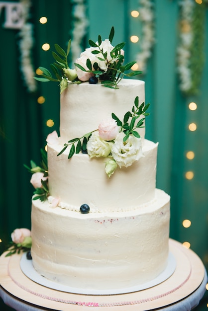 Three-tiered wedding cake with fresh flowers