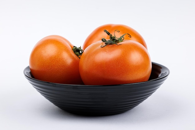 Three tomatoes on a black plate