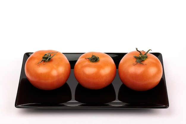 Three tomatoes on white background.