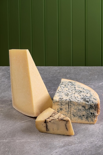 Three types of cheese parmesan and gorgonzola Old aged cheese blue cheese Gourmet appetizer italian traditional food on gray marble