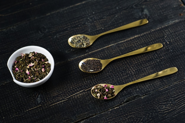 Photo three types of tea in spoons - green, black and rooibos