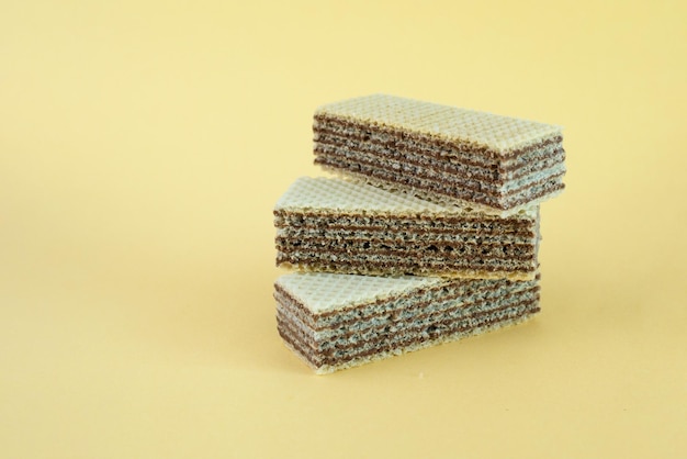 Three waffles with brown filling on a yellow background