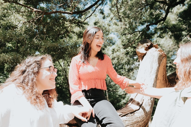 Three woman having a fun day in the forest, multicultural and friendship concept, care and love