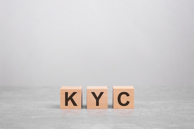 Three wooden blocks with the letters KYC on the gray table business concept