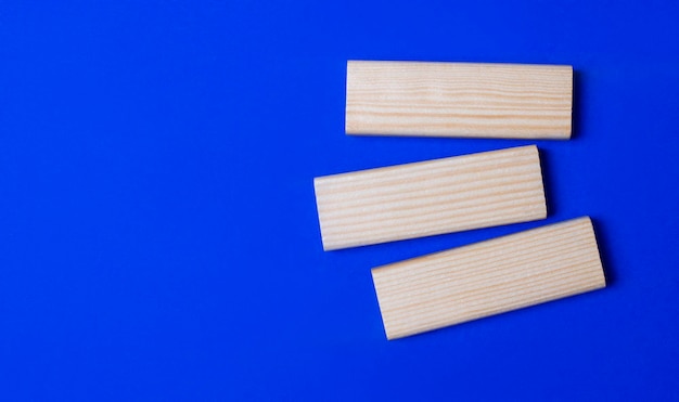 Three wooden blocks with space to insert text on a blue background Copy space